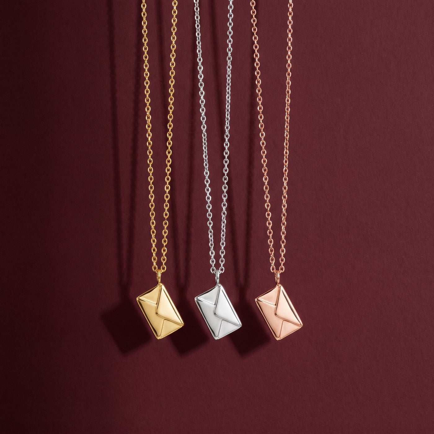 Colar envelope em dourado, prateado e rosé