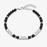 Pulseira Guardião da Família em aço preto mate com pendentes gravados, fundo cinzento