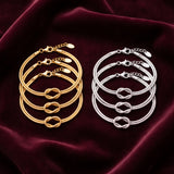 Pulseiras do nó em dourado e prateado
