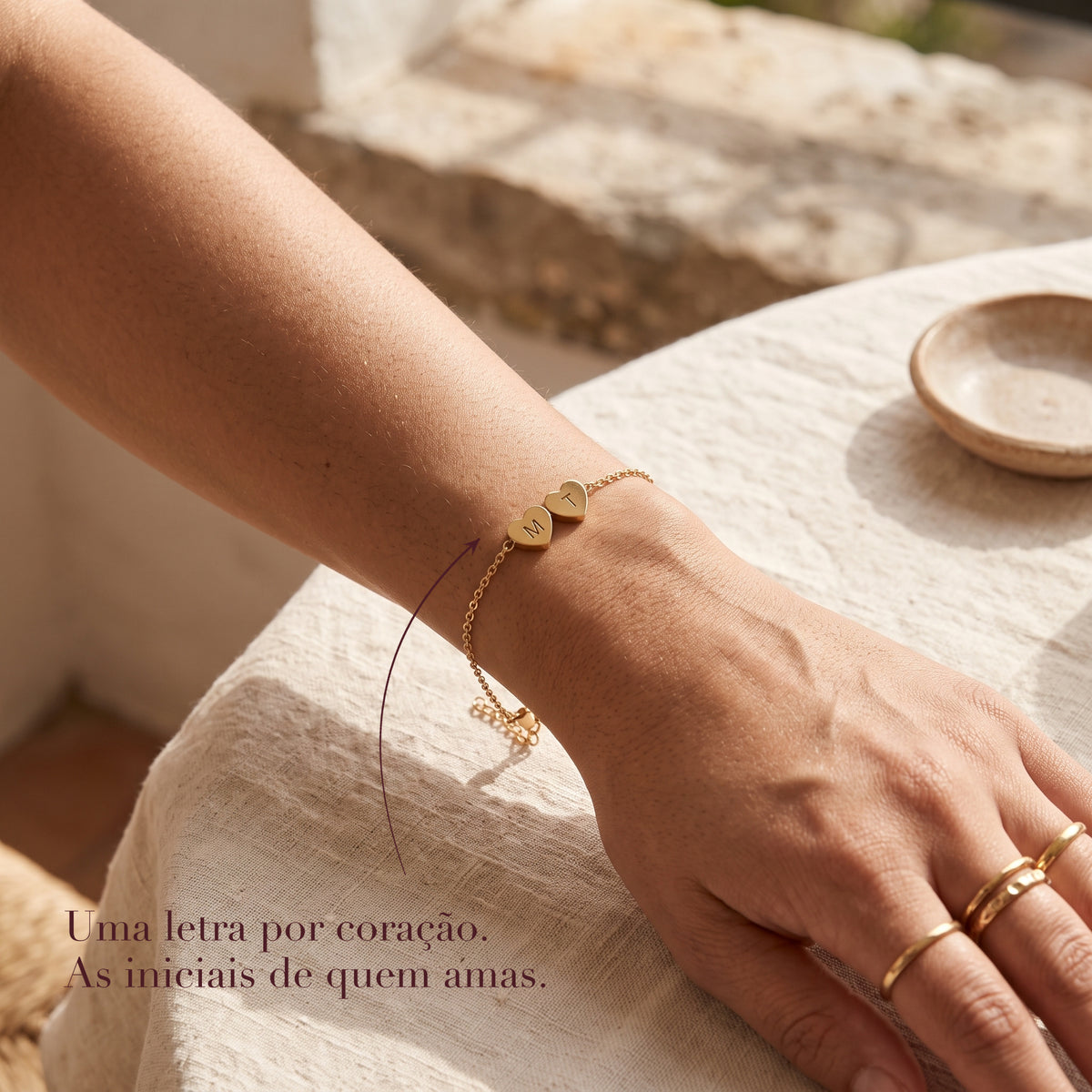 Pulseira de corações com iniciais no pulso